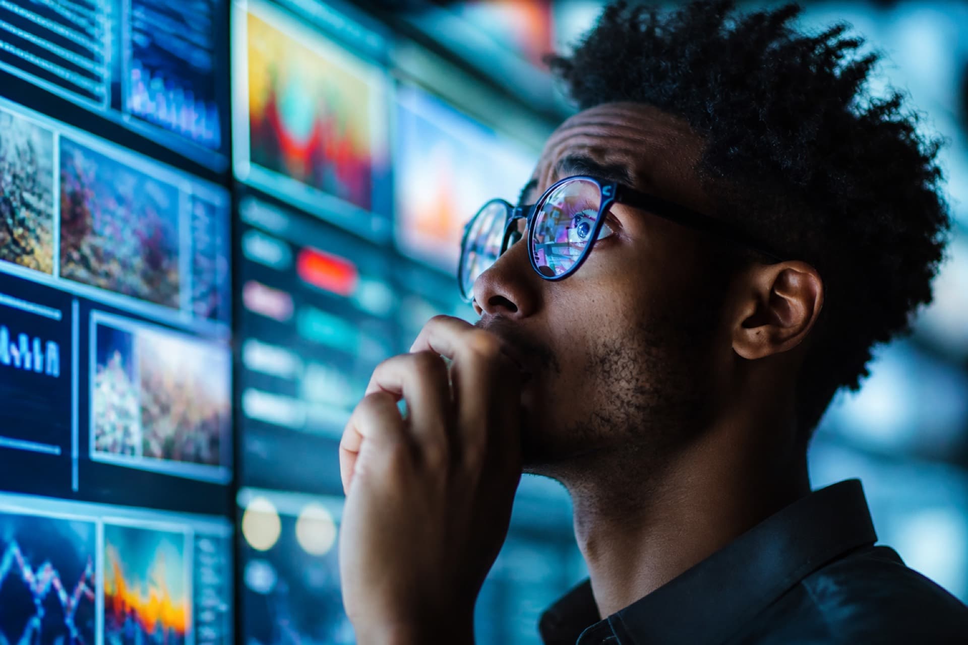 Analyst reviewing a wall of digital screens